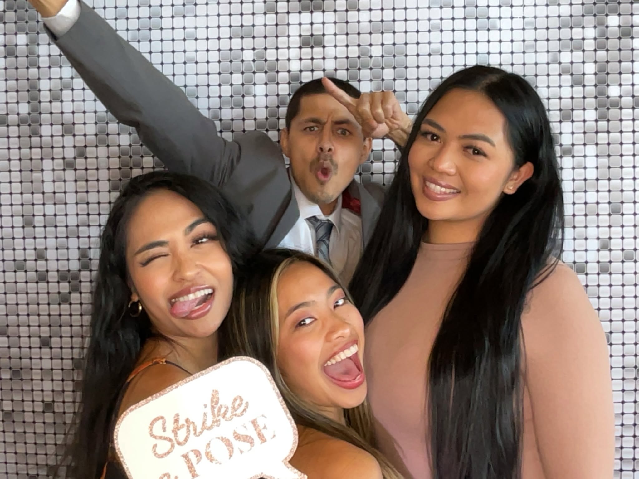 Wedding guests striking a fun pose in a photo booth