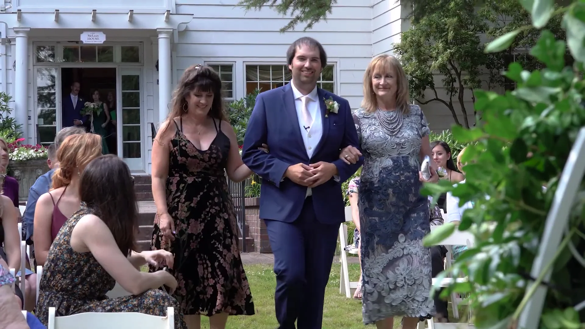 Video still of the groom walking with family outside McLean House