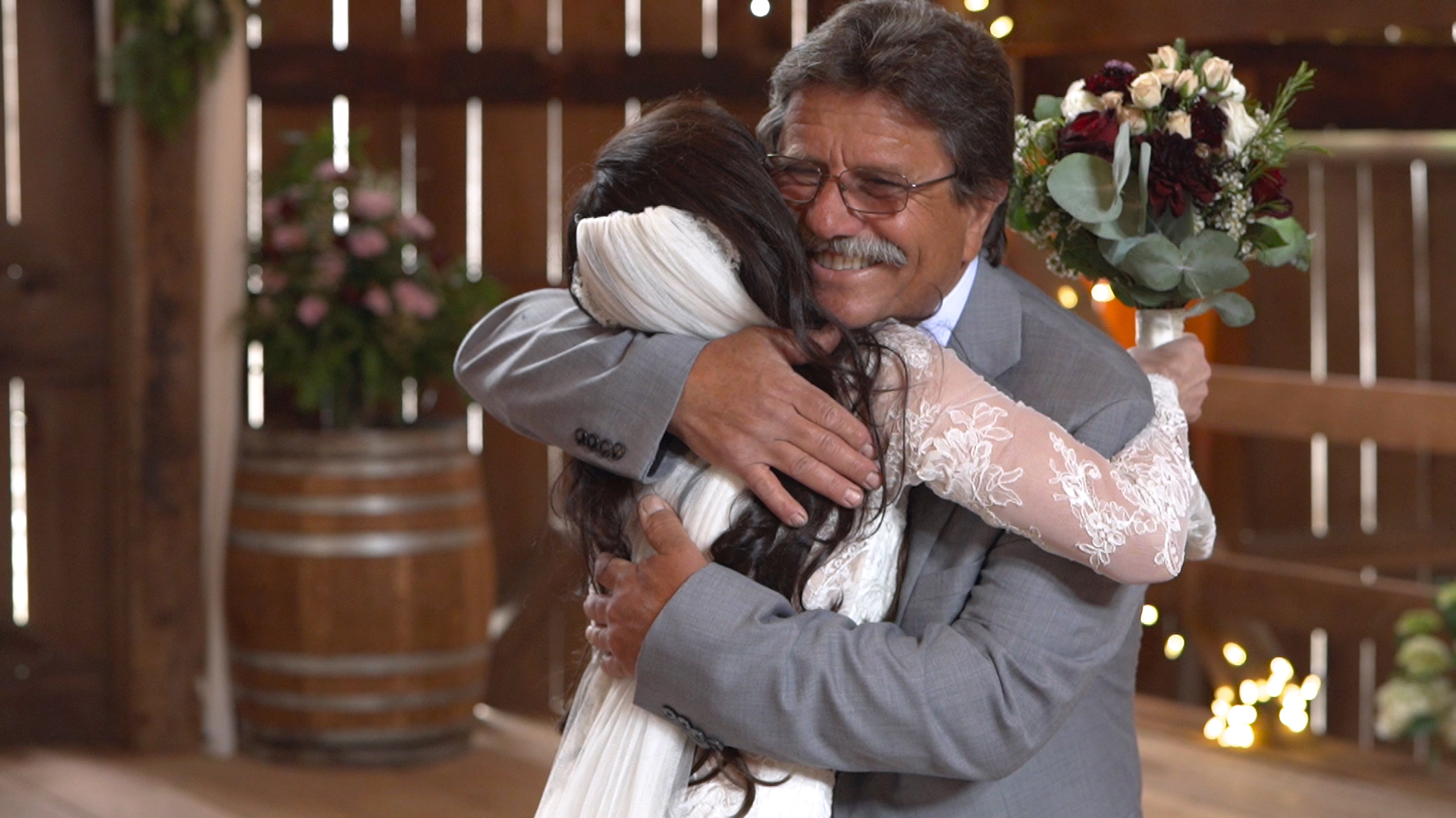 Father of the bride embracing the bride in a Pebble wedding film